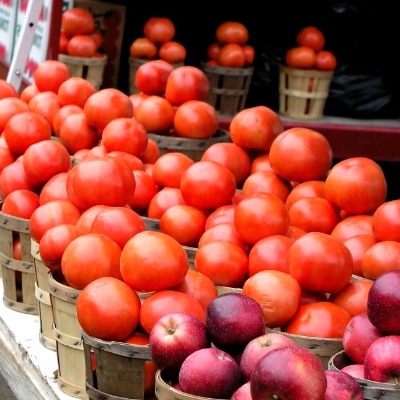 apples and tomatoes in baskets at farmer's market