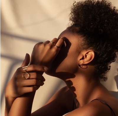 profile photograph of a young black woman covering her face