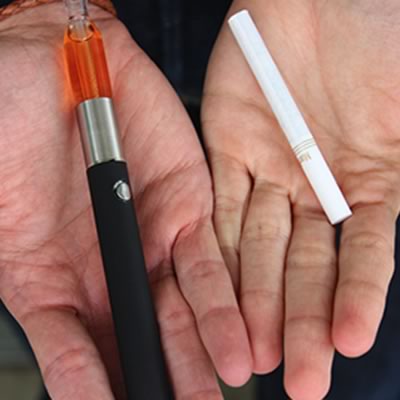 E-cigarette and cigarette in hands
