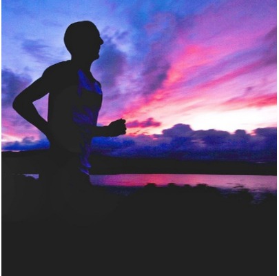 man running past purple sky and water