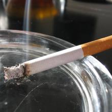 photograph of a cigarette burning in an ashtray