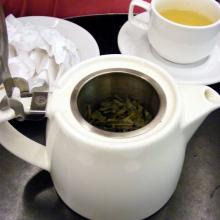 té verde en una tetera con una taza cerca