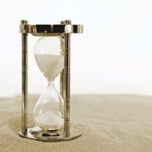 An hourglass with sand running.
